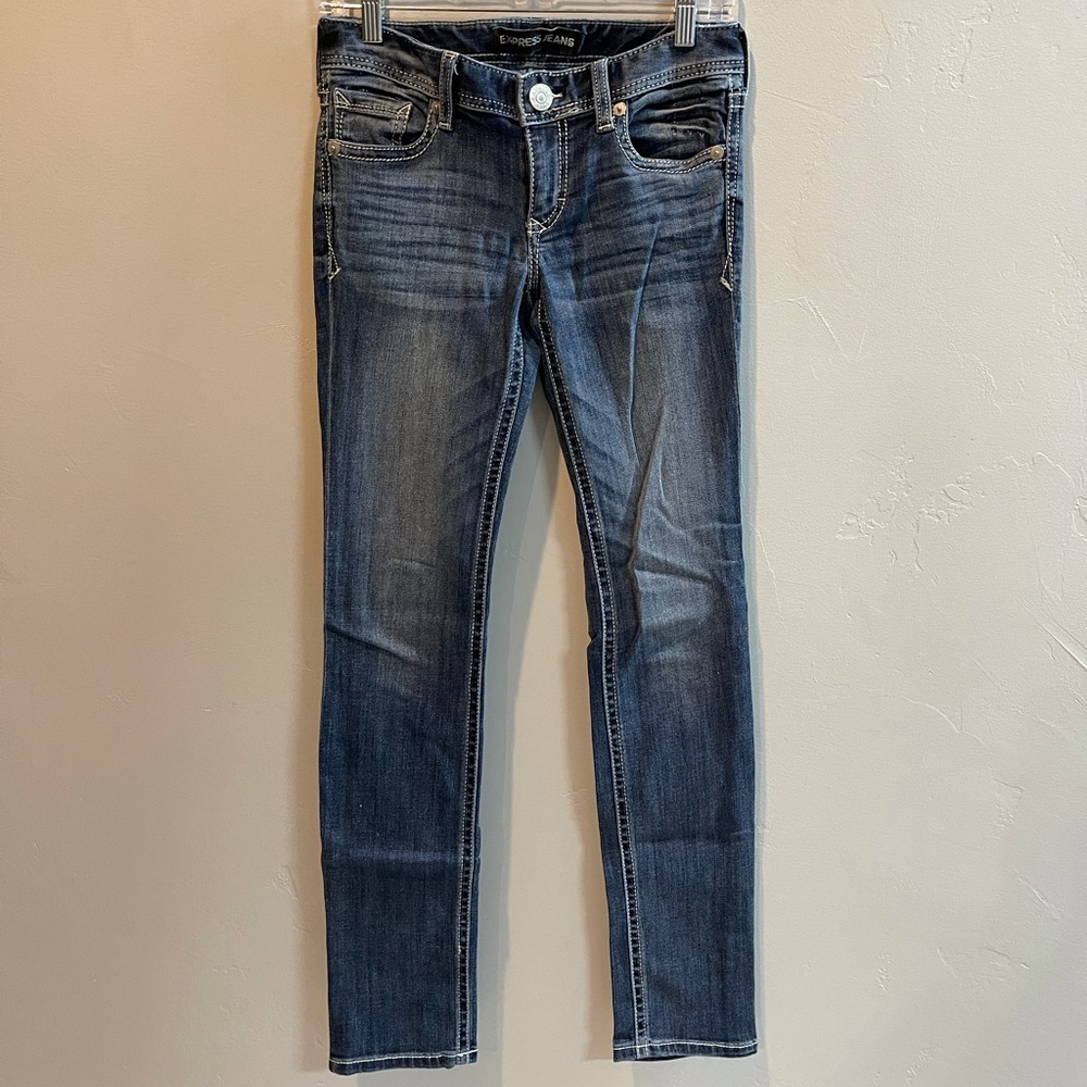 Women’s Express skinny low rise medium wash jean with accent stitching.